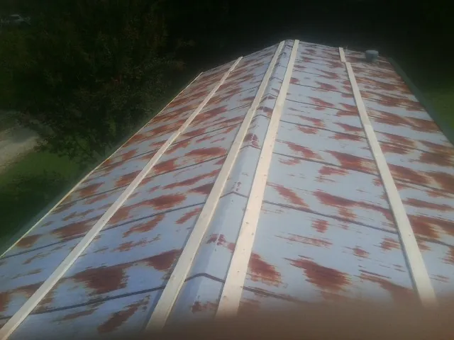 Rusted metal roof panels with new wood purlins before replacement — Storm Damage Roof Repair in Burket by Roofing Brothers