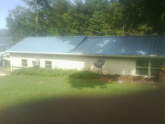 Blue metal roof running the length of a single story home in Burket