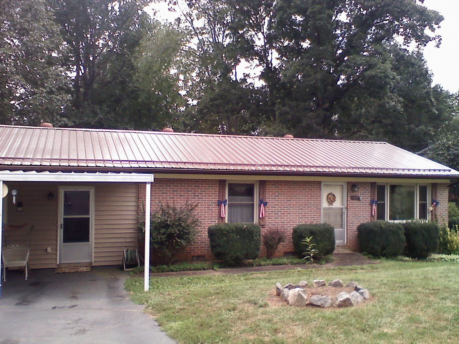 Bronze metal roof and carport on a brick ranch home — Roof Repair work by our crew in Burket